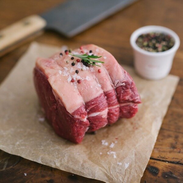 Rolled joint of roast beef garnished with peppercorns
